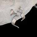 Detailed close-up of silver spiral earrings with polished finish on black and white fabric - 26# Silver Needle-Silver-Abstract Liquid Wave (Geometric)