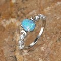 Macro detail of oval blue opal celestial ring with moon accents and zircon stones - US 5 / Blue