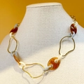 Modische Gliederkette mit bernsteinfarbenem Harz und goldenen Metallringen auf Orange - Goldbasis - Bernstein/Elfenbein/Graublau