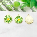 Detailed macro view of three gold-plated enamel daisy charms with green petals on marble - 16x18mm / Green