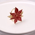 Elegant red poinsettia flower napkin ring with gold metallic petals on a white plate - Christmas Flower
