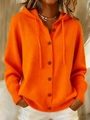 Nahaufnahme einer orangefarbenen Strickjacke mit Kapuze, Knöpfen und Kordelzug - Orangerot