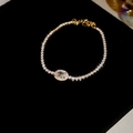 Macro detail of a gold zircon bracelet with oval center stone on black velvet - Gold
