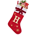 Close-up of red velvet Christmas stocking with white knit cuff and gold sequined letter H - Red H