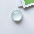 Round light blue cat eye stone phone grip with smooth surface on white desk - Healing Blue Crystal Ball