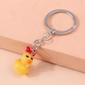 Cute yellow duck keychain with red bow tie and silver metal ring on pink block - Yellow Duck