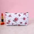 White floral cosmetic bag with pink butterfly patterns and golden zipper on marble surface - White Base Floral