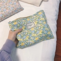 Close-up of floral cotton makeup bag featuring a zipper and TIME TO PARTY woven label - White with Yellow and Green Flowers