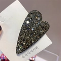 Detailed close-up of a heart-shaped hair clip featuring pave-set dark grey Czech crystals - Gray