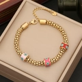 Dettaglio del bracciale dorato con ciondoli occhio malvagio in smalto rosa e rosso su scatola - Stile 4 Occhio del Diavolo Rosso
