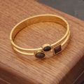 Dettaglio di un bracciale dorato a doppio strato con pietre nere e rosse scure - Stile Pietra Preziosa Nera e Rossa a Doppio Strato (3#)