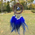 Handmade dream catcher with blue natural stones and feathers hanging outdoors - Lapis Lazuli Brown Hoop