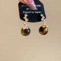 Detailed shot of tiger eye stone drop earrings with S-shaped zircon studs on silver card - Gold Plated Copper + 925 Silver Pin + Tiger's Eye / Wave Bead Earrings (HE29835)