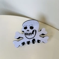 Detailed view of skull and crossbones hair claw clip for Halloween festive styling - Skull