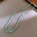 Detailed close-up of emerald green faceted crystal beaded necklace on a grey velvet background - Green Round Bead Necklace(5#)