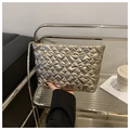 Close-up of golden quilted heart pattern cosmetic bag with metallic finish texture - Gold