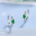 Detail of silver hoop earrings featuring oval green gemstones and white diamond accents - Green Zirconia