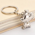 Polished silver metal keychain featuring a cute 3D deer charm on a vintage book backdrop - Lucky Deer / Silver