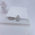 Detailed view of silver lip-shaped earrings with cubic zirconia on white plaster - Silver Lip