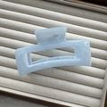 Macro detail of a light blue rectangular hair claw clip with ink marble texture on beige tray - Blue Rectangle 10.5cm