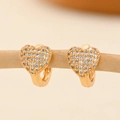 Close-up of heart-shaped gold earrings with paved zircon on a wooden display stand - EH234 Heart Classic Style
