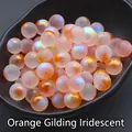 Foto macro de cuentas de vidrio naranja irisado de 12 mm con pan de oro en bandeja negra - 12mm Sin Agujeros / Naranja Iridiscente