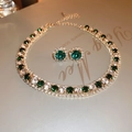 Dettaglio del set di gioielli vintage dorati con pietre verdi e orecchini tondi - Set da 2 Pezzi Collana e Orecchini con Strass Verdi