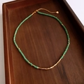 Detail of green aventurine beaded necklace with gold plated accents on wooden tray - Green/Gold (Gold Plated)