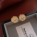 Macro-opname van camelia-oorbellen met gouden basis, witte bloemblaadjes en kristallen - Goud (Zilveren oorsteker)