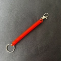 Roter Spiralschlüsselanhänger aus Kunststoff mit Metallring und Karabiner auf Textur - 25mm Ring / Orange