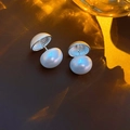 Gros plan détaillé de boucles d'oreilles perles argentées sur cuir sombre luxueux - Argenté
