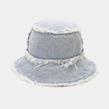 Detail view of frayed edges and twill texture on a washed denim reversible bucket hat - One Size / Light Blue