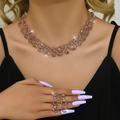 Detailed view of rose gold bridal jewelry set featuring hollow mesh chain and pink gems - Gold Purple