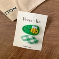 Green fabric hair clip set featuring embroidered bee and green checkered bow patterns - Bee + Plaid