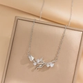 Elegante collar de tulipán plateado con circonitas brillantes sobre soporte champagne - Color Acero-Tulipán