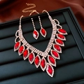 Détail du collier et des boucles d'oreilles en pierres rouges marquises sur support noir - Collier-Or-Rouge