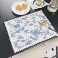 Blue floral linen placemat with double-layered lace edges on a dark table setting - Blue Rose