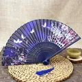 Detail of blue folding fan with white butterflies, pink cherry blossoms and silk tassel - Blue Butterfly Flower