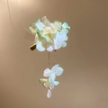 Detailed view of elegant fabric flower hair clip with cascading pearl tassels and petals. - Sweet Resort Hair Clip / Green