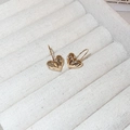 Gros plan de boucles d'oreilles cœur dorées avec texture plissée dans un écrin à bijoux - Crochets de boucles d'oreilles / Doré