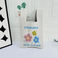 Beige knitted tote bag featuring three colorful cartoon flowers and blue text embroidery - Three Flowers Beige