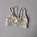 Detail view of criss-cross back straps and adjustable hook closure on green sports bra - S / Tops / Light Green