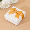 Elegant white square paper jewelry gift box featuring a decorative golden ribbon bow - Gold Bow Box