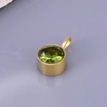 Detail of a round emerald green birthstone pendant with gold plated stainless steel frame - Round Pendant / Light Green