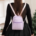 Women's purple seersucker striped mini backpack with pink straps in a home setting - Purple