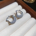 Macro detail of silver-tone hoop earrings with shimmering pavé zircon stones in a jewelry box - Silver