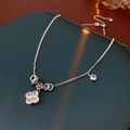 Détail macro d'un collier pendentif fleur en argent avec zircons sur boîte à bijoux - Argent (Plaqué Or Véritable)