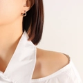 Minimalist square hoop earrings in silver finish worn by a model in a close-up view - Square / Silver
