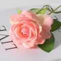 Artificial pink velvet rose stem with realistic leaves on a white decorative magazine - Champagne Pink