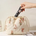 Close-up of quilted beige bear pattern drawstring pouch with hand cream in a set - Beige Bear